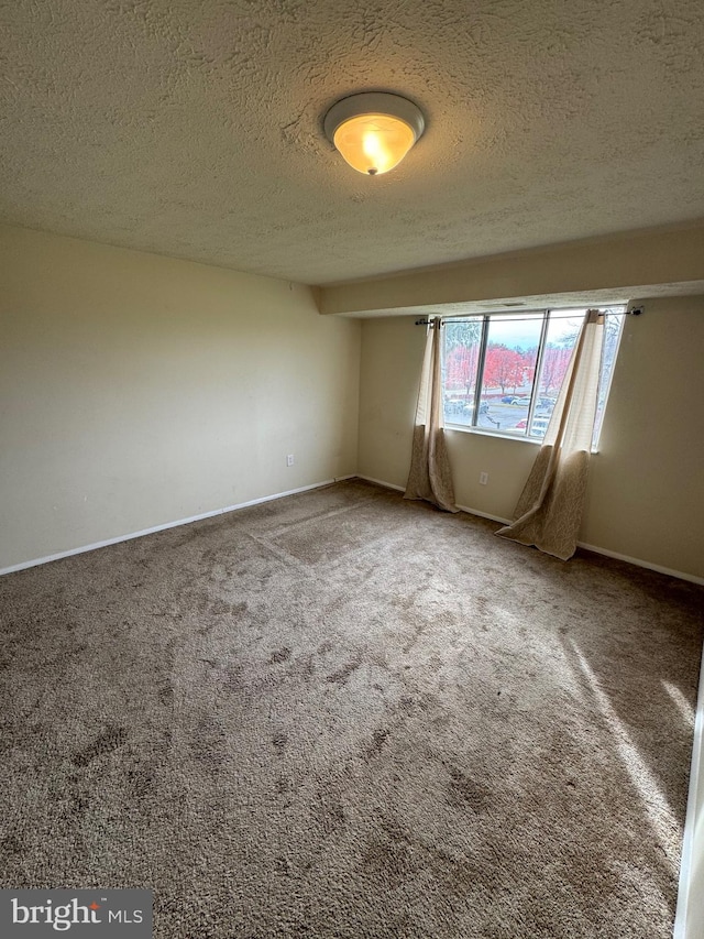 carpeted empty room with a textured ceiling