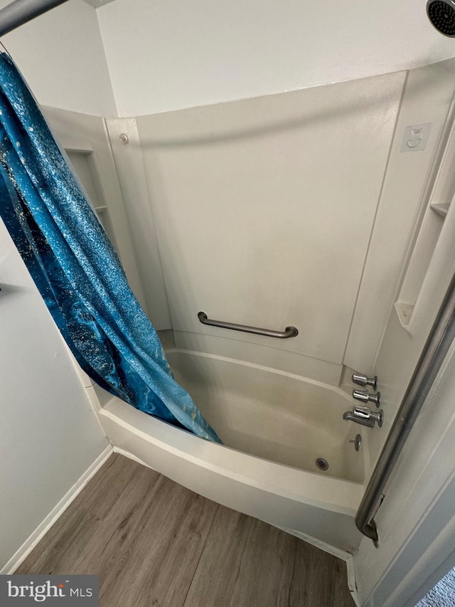 bathroom featuring hardwood / wood-style flooring and shower / bath combo with shower curtain