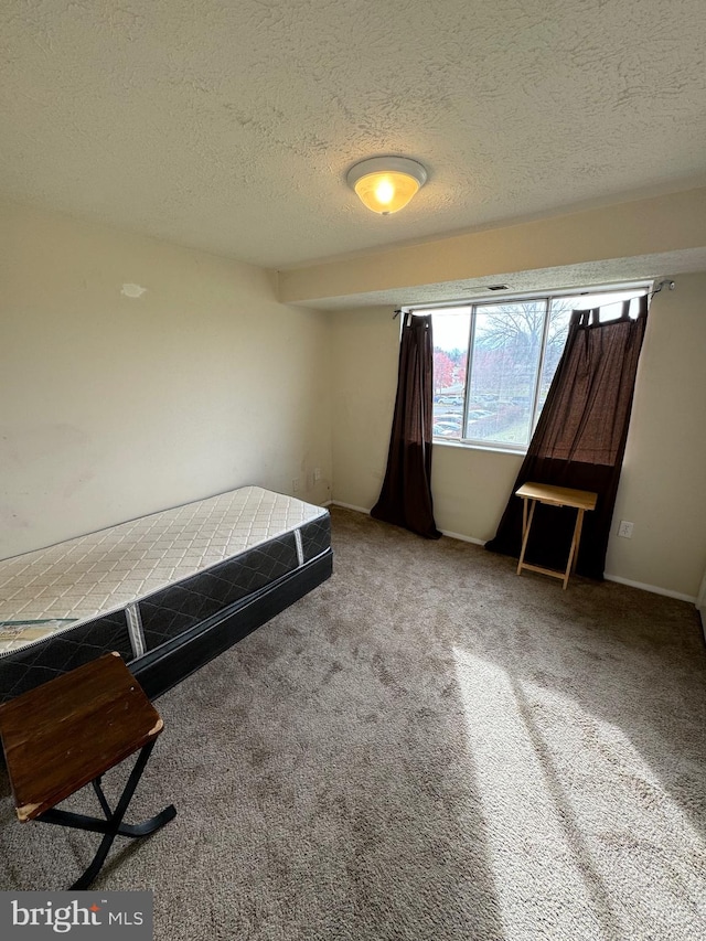 unfurnished bedroom featuring carpet flooring and a textured ceiling