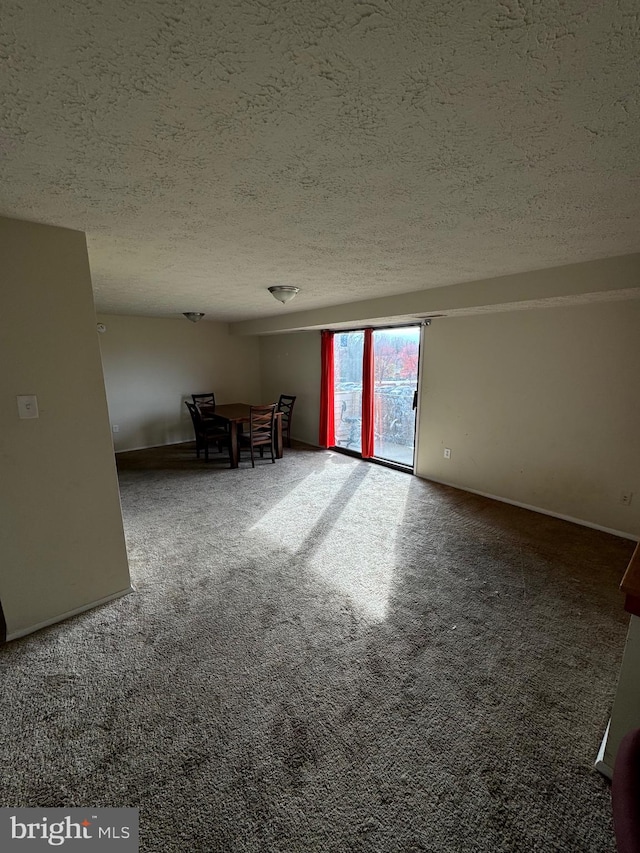 spare room featuring carpet and a textured ceiling