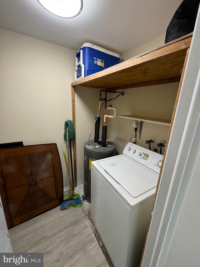 washroom featuring electric water heater, washer / clothes dryer, and light hardwood / wood-style flooring