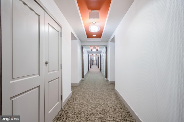 hallway with light colored carpet and baseboards