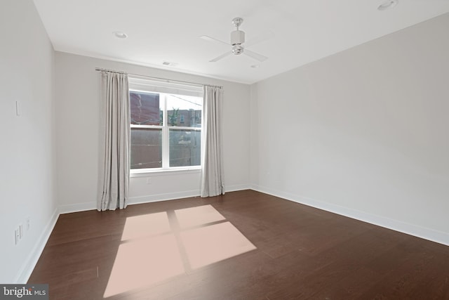 unfurnished room with a ceiling fan, baseboards, and wood finished floors