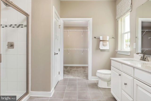 bathroom with toilet, vanity, tile patterned floors, and walk in shower