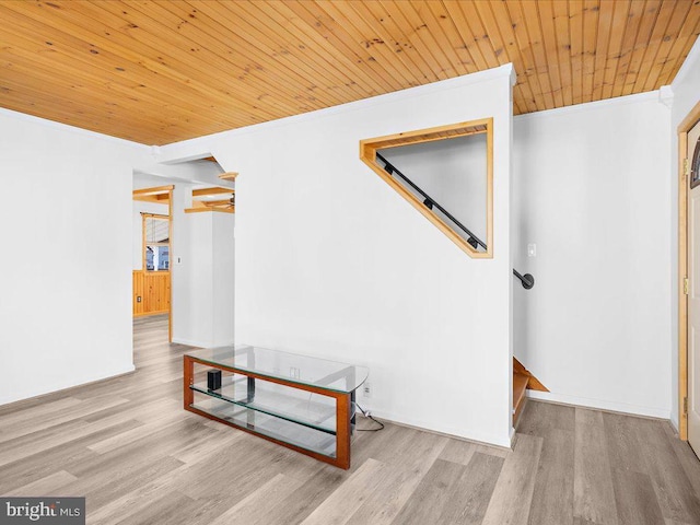 corridor with light hardwood / wood-style flooring, crown molding, and wood ceiling