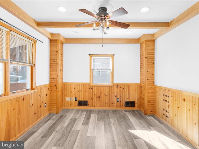 unfurnished room with wood walls, light hardwood / wood-style flooring, and ceiling fan