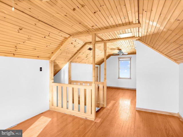 additional living space with lofted ceiling with beams, hardwood / wood-style floors, ceiling fan, and wooden ceiling