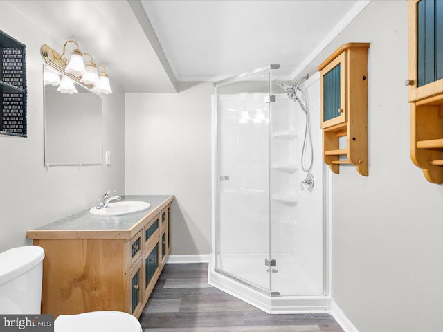 bathroom featuring wood-type flooring, vanity, toilet, and a shower with shower door