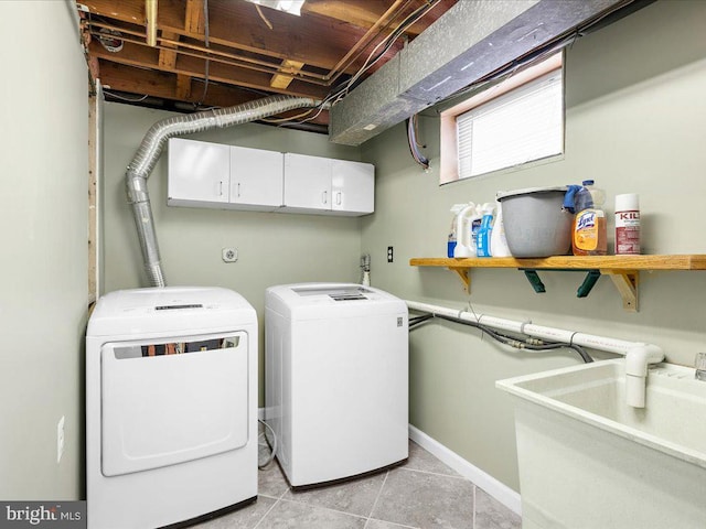 clothes washing area featuring cabinets, independent washer and dryer, sink, and light tile patterned floors