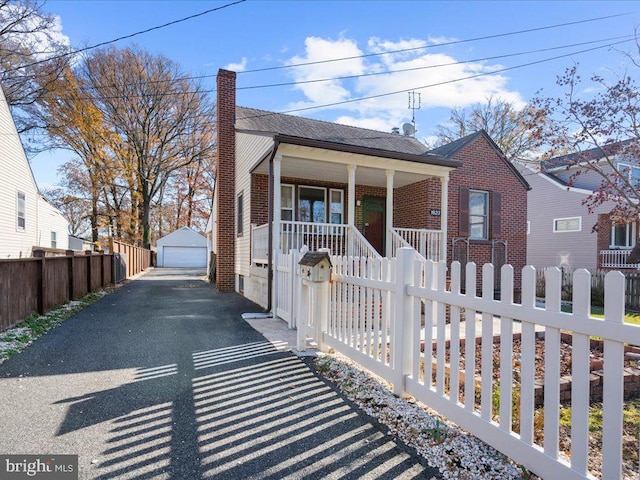 bungalow-style house featuring covered porch, an outbuilding, and a garage