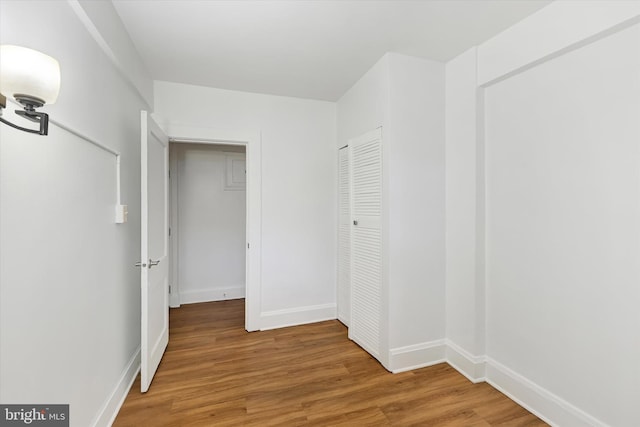 hallway with hardwood / wood-style flooring