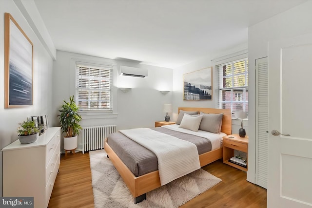 220 Stony Run Ln Unit Dg, Baltimore, MD 21210 - bedroom featuring radiator, a wall mounted AC, and wood finished floors