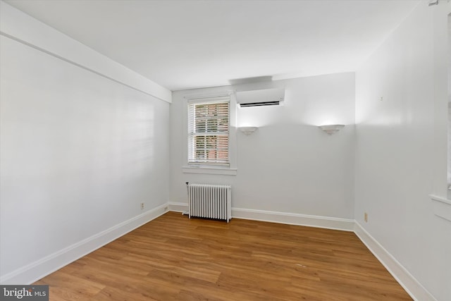 220 Stony Run Ln Unit Dg, Baltimore, MD 21210 - unfurnished room featuring radiator, an AC wall unit, light wood-type flooring, and baseboards