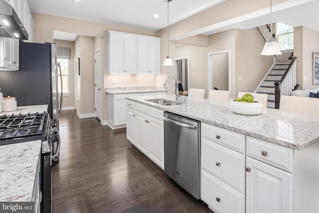 kitchen featuring white cabinets, appliances with stainless steel finishes, pendant lighting, and exhaust hood