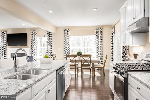 kitchen featuring stainless steel appliances, dark wood-type flooring, sink, pendant lighting, and white cabinets