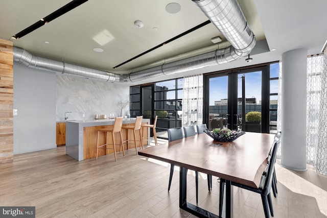 dining room with french doors and light wood-type flooring