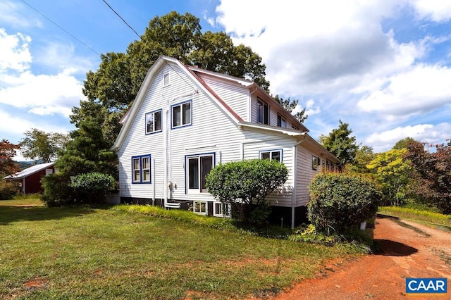 view of side of home with a yard