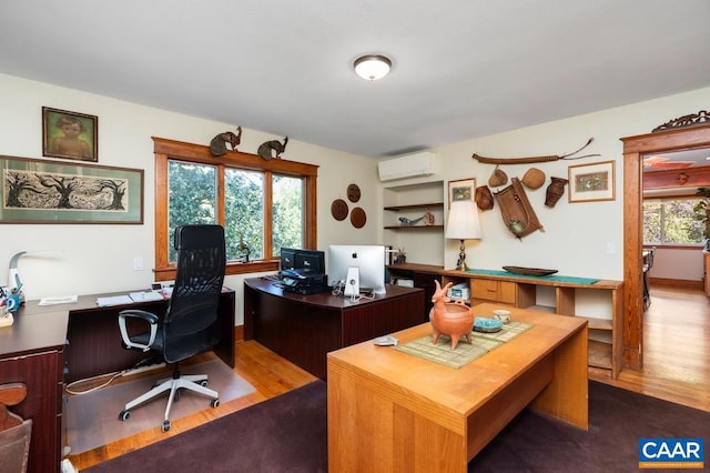 home office featuring an AC wall unit and hardwood / wood-style floors