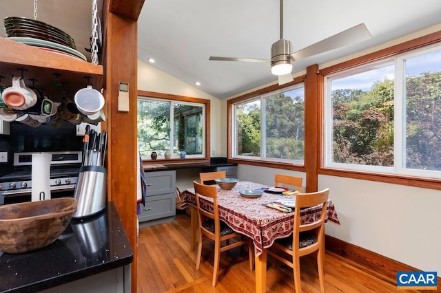 dining area featuring ceiling fan, lofted ceiling, and light wood-type flooring