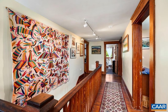 corridor with dark hardwood / wood-style flooring and rail lighting