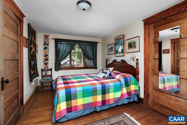 bedroom with dark hardwood / wood-style floors