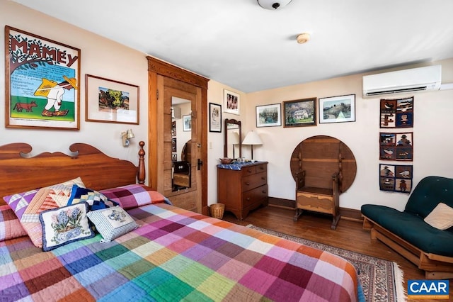 bedroom with an AC wall unit and hardwood / wood-style floors