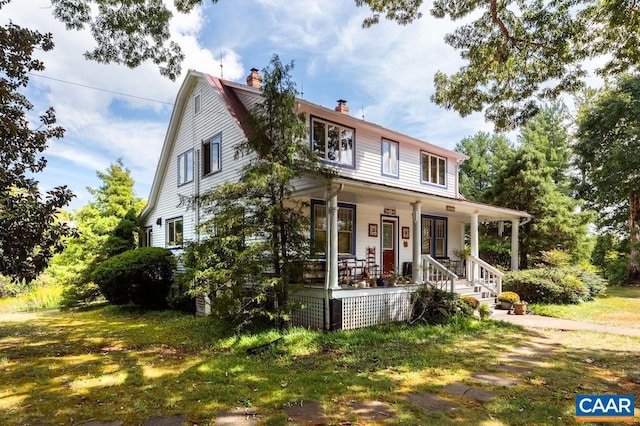 farmhouse featuring a front lawn and a porch