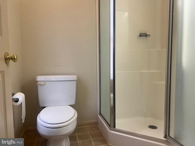 bathroom with a shower with shower door and toilet