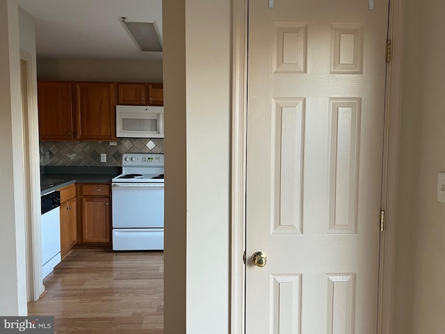 kitchen featuring white appliances, tasteful backsplash, and light hardwood / wood-style flooring