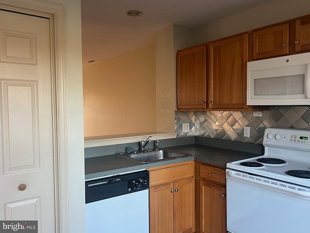 kitchen featuring decorative backsplash, sink, and white appliances