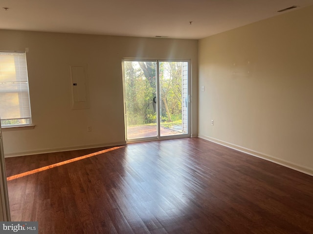 empty room with electric panel and dark hardwood / wood-style floors