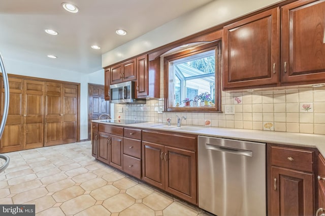 kitchen featuring decorative backsplash, sink, light tile patterned floors, and stainless steel appliances