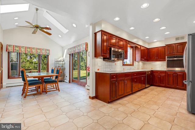 kitchen featuring a skylight, ceiling fan, a baseboard radiator, tasteful backsplash, and appliances with stainless steel finishes