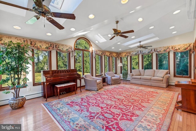 interior space with a baseboard radiator, lofted ceiling with skylight, and a wealth of natural light