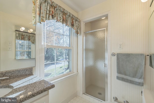 bathroom featuring a wealth of natural light, tile patterned flooring, vanity, and a shower with shower door