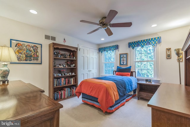 carpeted bedroom featuring ceiling fan and a closet