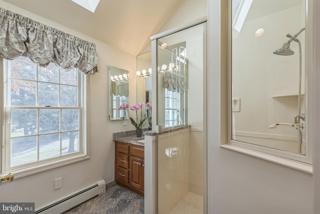 bathroom featuring vanity, a healthy amount of sunlight, vaulted ceiling, and a baseboard heating unit