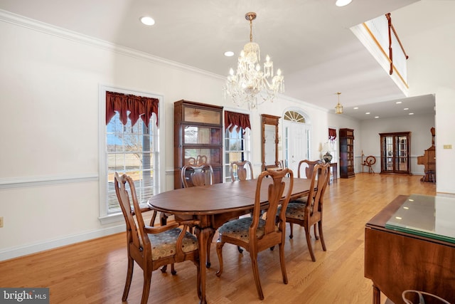 dining room featuring a chandelier, light hardwood / wood-style floors, and crown molding