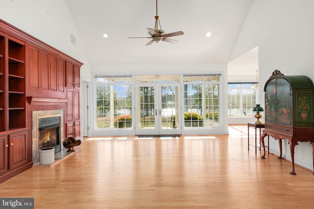 living room with light wood-type flooring, high vaulted ceiling, and ceiling fan