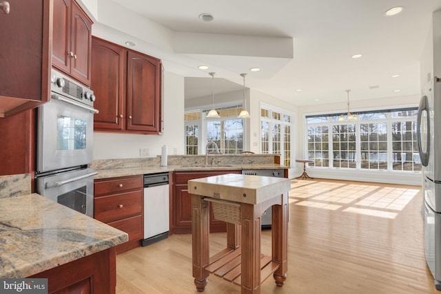 kitchen featuring a wealth of natural light, pendant lighting, and light hardwood / wood-style floors