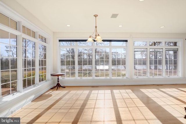 unfurnished sunroom with a notable chandelier and a healthy amount of sunlight