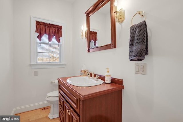 bathroom featuring toilet, vanity, and hardwood / wood-style flooring