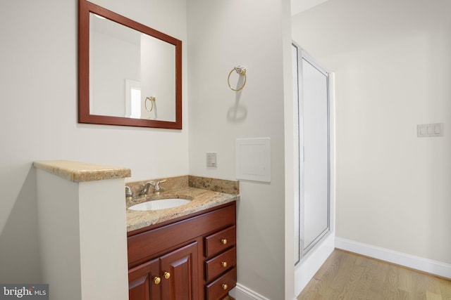 bathroom featuring hardwood / wood-style floors, vanity, and an enclosed shower