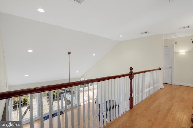 hallway featuring lofted ceiling and light wood-type flooring