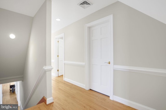 hall featuring light hardwood / wood-style floors and lofted ceiling