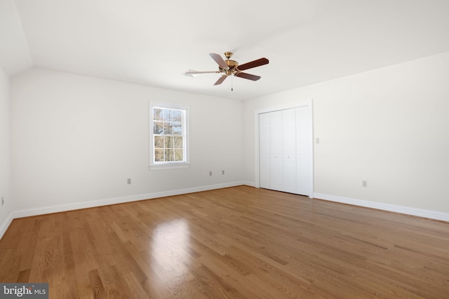 empty room with hardwood / wood-style flooring, ceiling fan, and lofted ceiling