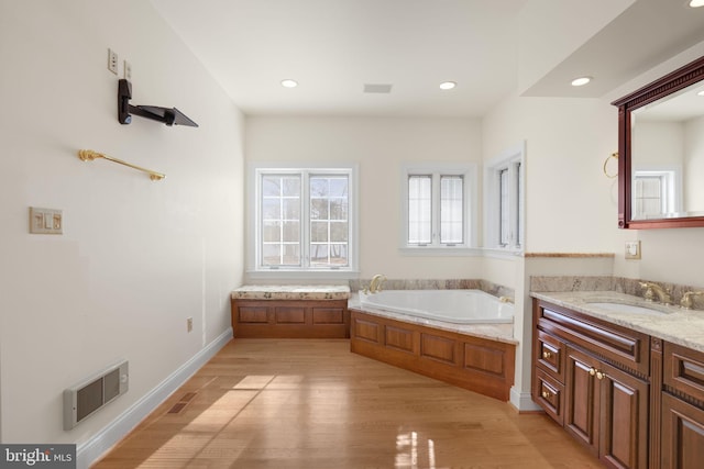 bathroom with vanity, wood-type flooring, and a tub