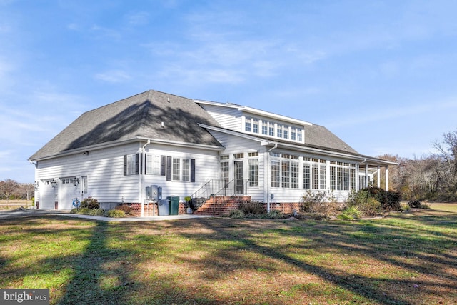 back of house with a garage and a lawn