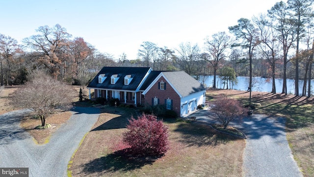 view of front of home with covered porch, a garage, and a water view