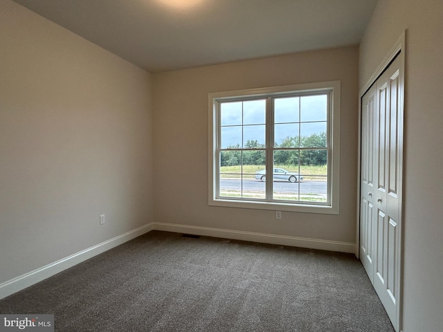 spare room with dark colored carpet